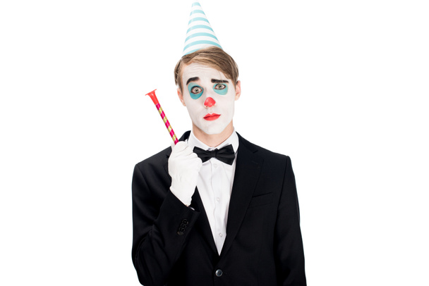 clown in suit and birthday cap holding blower isolated on white  - Фото, изображение