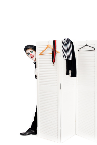 clown gai en béret noir regardant par la porte du vestiaire isolé sur blanc
  - Photo, image