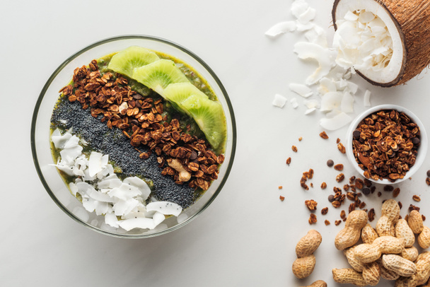 top view of healthy green smoothie bowl with ingredients on white background - Photo, Image