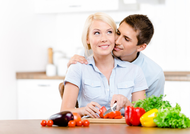 Man kisses girl while she is cooking - Foto, imagen