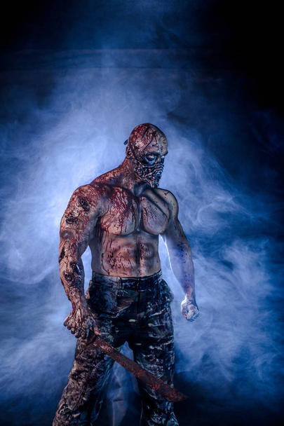portrait of male zombie killer with machete against misty background - Φωτογραφία, εικόνα