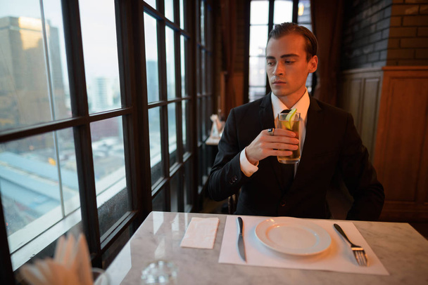 Nuoren liikemiehen muotokuva, jolla on juomaa ravintolassa
 - Valokuva, kuva