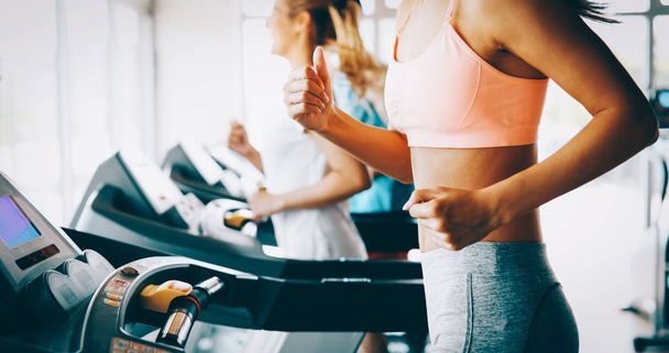 Young attractive woman doing cardio training for weight loss in gym - Fotoğraf, Görsel