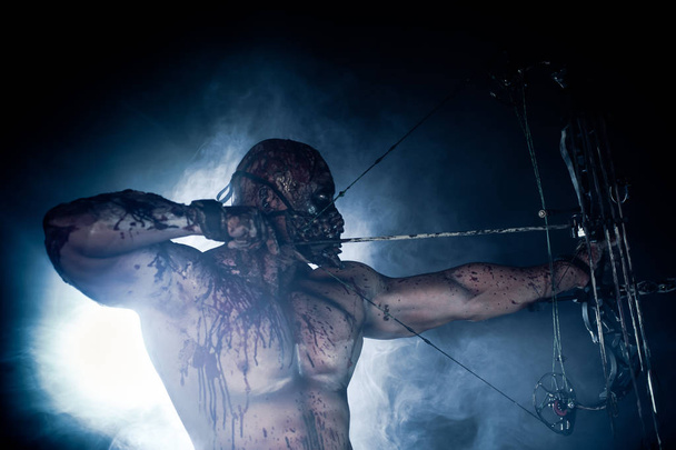 м'язистий вбивця зомбі з сучасним бантом позує на темному тлі
 - Фото, зображення