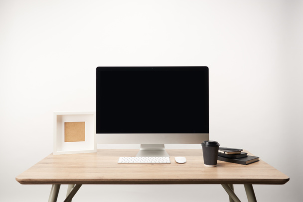 workplace with coffee to go, notebooks, photo frame and desktop computer with copy space isolated on white - Fotó, kép