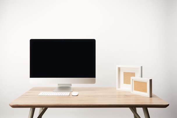 workplace with photo frames and desktop computer with copy space isolated on white - Photo, Image