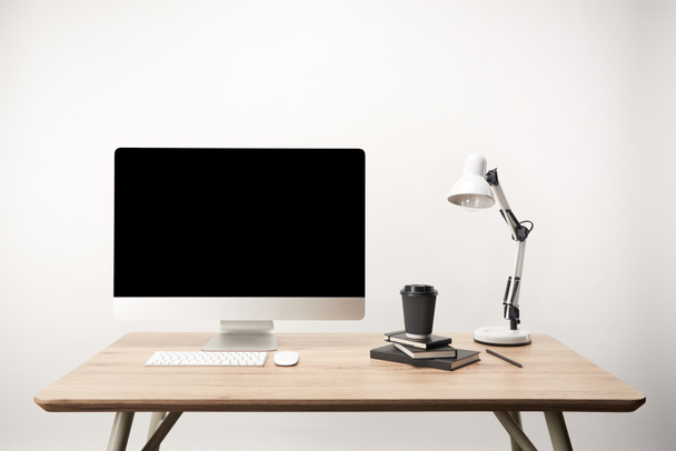 workplace with lamp, coffee to go, notebooks and desktop computer with copy space isolated on white - Fotografie, Obrázek