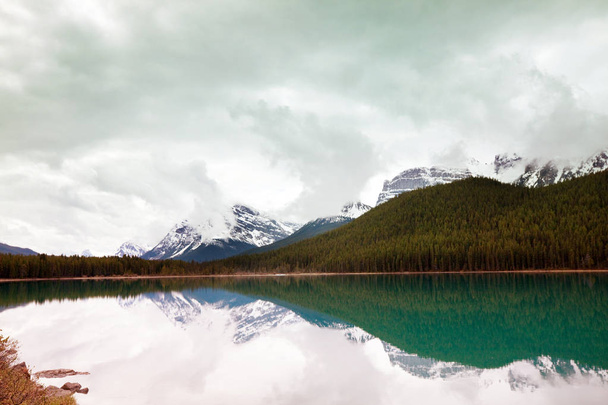 Tyyni kohtaus vuoristojärven rannalla Kanadassa heijastus kiviä tyynessä vedessä. - Valokuva, kuva