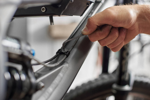 close-up de homem serviço profissional reparando bicicleta de montanha usando instrumento especial
 - Foto, Imagem