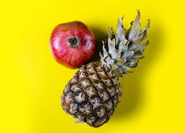 Pomegranate pineapple fruit on a yellow background, top view - Photo, Image