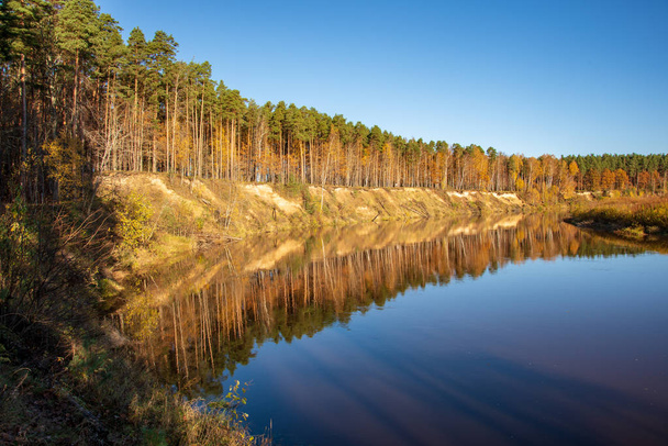 modrá obloha a mraky odrážející v klidné vodě řeky Gauja v Lotyšsku na podzim. Procházka na břehu řeky. Vymažte podzimního dne. široký úhel pohledu - Fotografie, Obrázek