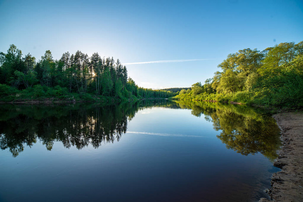 ciel bleu et nuages se reflétant dans l'eau calme de la rivière Gauja à Latvia en automne. marcher sur la rive de la rivière. clair jour d'automne. vue grand angle
 - Photo, image