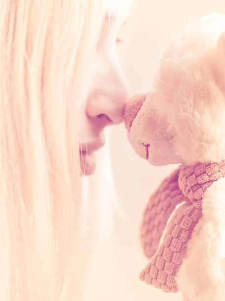 Portret van een meisje met een zacht stuk speelgoed Beer neus aan neus - Foto, afbeelding