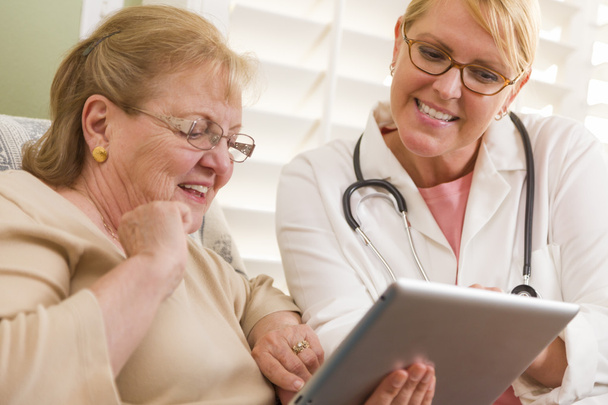 Arzt oder Krankenschwester im Gespräch mit Seniorin mit Touchpad - Foto, Bild