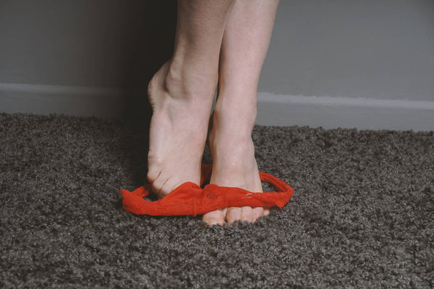 Kırmızı tanga külot tanınmaz halde kadının ayak bilekleri çevresinde - Fotoğraf, Görsel