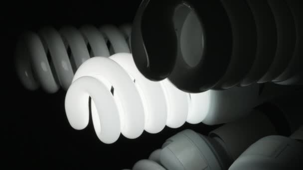 Lâmpadas espirais de poupança de energia ecológica brilham no escuro. Panning em câmera lenta, tiro de close-up
 - Filmagem, Vídeo
