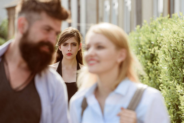 Terribly jealous of them. Romantic couple of man and woman dating. Bearded man cheating his girlfriend with another woman. Jealous woman look at couple in love on street. Unhappy girl feeling jealous - Fotoğraf, Görsel