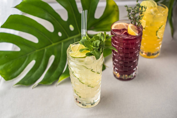 Fresh fruit cocktails in glasses with green leaf on background - 写真・画像