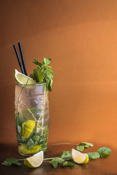 close-up view of glass with delicious mojito cocktail on brown background - Fotó, kép