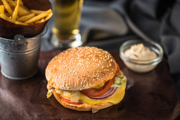 Tasty burger with french fries on wooden board - Valokuva, kuva