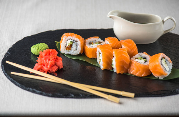 Japanese sushi roll served on slate with chopsticks - 写真・画像