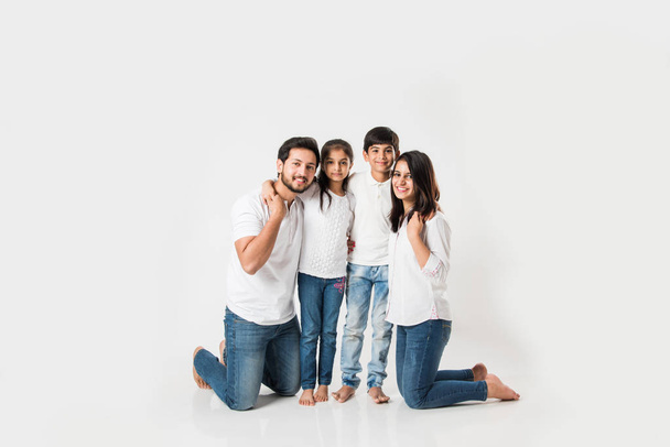 Young Indian family sitting isolated over white background. selective focus - 写真・画像
