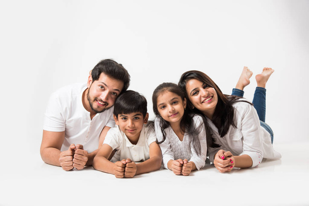 Familia india feliz acostada en el suelo blanco, enfoque selectivo - Foto, imagen