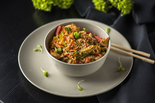 Bowl of asian noodles on plate with chopsticks on black fabric - Foto, Imagem