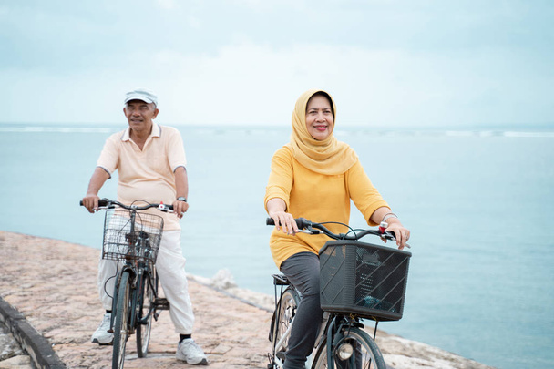 happy senior muslim couple exercising riding bicycle together  - Fotoğraf, Görsel