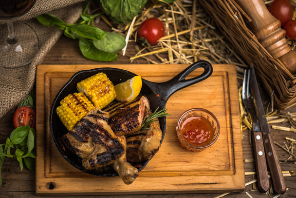 Жареное мясо с кукурузой в сковороде на деревянной доске
 - Фото, изображение