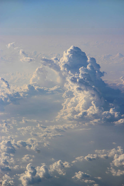 Prachtig uitzicht vanuit raam van het vliegtuig naar zon schijnt over wolken. Wolken verlicht door de stralen van de zon. Mooie witte wolken met zonnige stralen. Landschap met zon en lucht. Panorama van de hemel - Foto, afbeelding