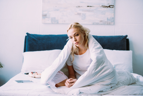foco seletivo de mulher triste solitário coberto de cobertor sentado na cama em casa
 - Foto, Imagem