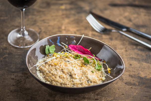 couscous served in bowl and garnished with sprouts on wooden table - 写真・画像