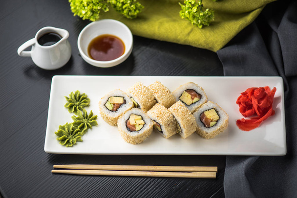 Portion of japanese traditional sushi roll served on black plate - Foto, Imagem