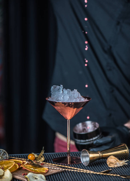 detail z barman v černé připravuje koktejl na pultu v baru - Fotografie, Obrázek