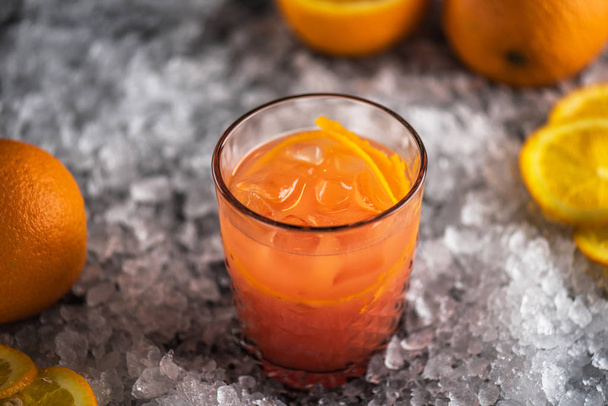 Orange cocktail in glass on ice with ingredients - Foto, imagen