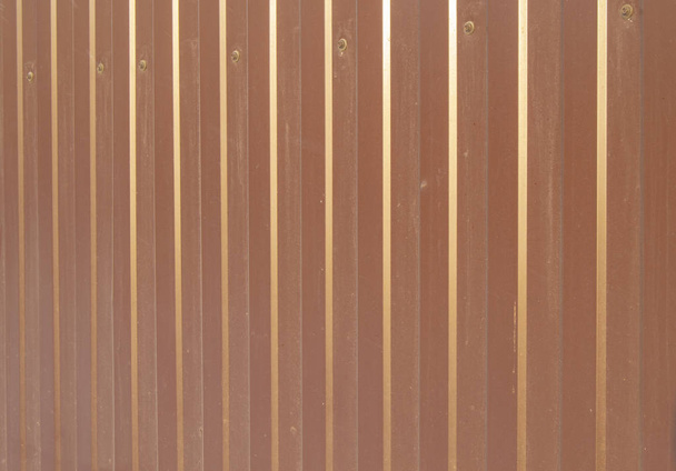 Revestimiento de metal marrón, material de acabado moderno para la fabricación de vallas y revestimiento de paredes exteriores. - Foto, imagen