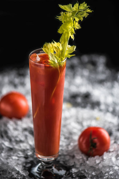 margarita cocktail served in glass and garnished with celery on dark background with ice - Photo, image