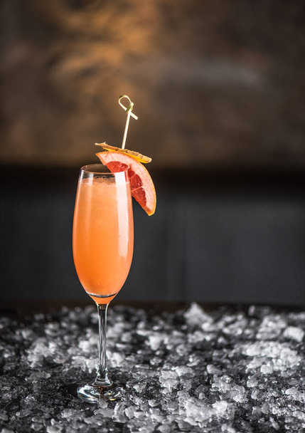 Grapefruit and ginger cocktail in glass on dark background - 写真・画像