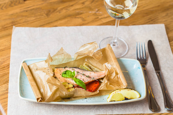 Baked piece of salmon on parchment with glass of white wine - Foto, immagini