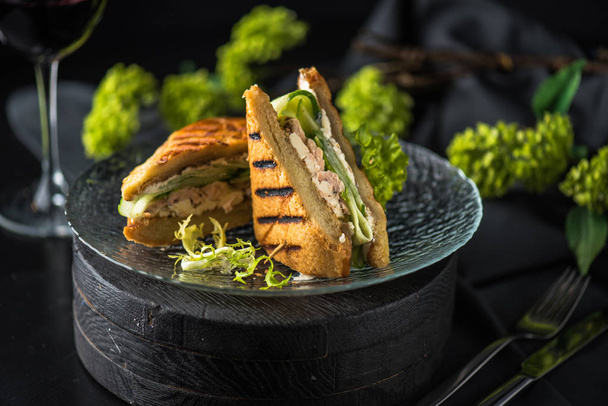 Chicken fried sandwich with vegetables served on plate on dark background - Valokuva, kuva