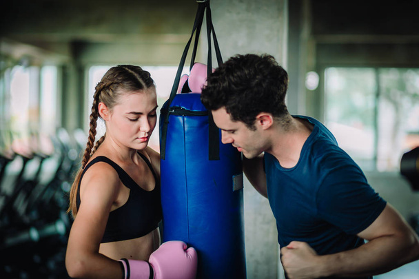 Fit beautiful woman boxer hitting a huge punching bag exercise class in a gym. Boxer woman making direct hit dynamic movement. Healthy, sport, lifestyle, Fitness, workout concept. With copy space. - Photo, Image