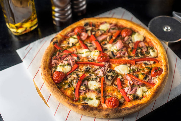 Detailní pohled chutné pizzy s masem a zeleninou na tmavý podklad  - Fotografie, Obrázek