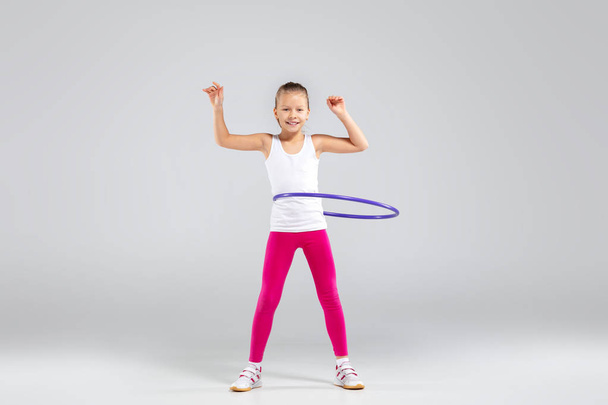 Lächelndes Mädchen macht Übungen mit Hula Hoop - Foto, Bild