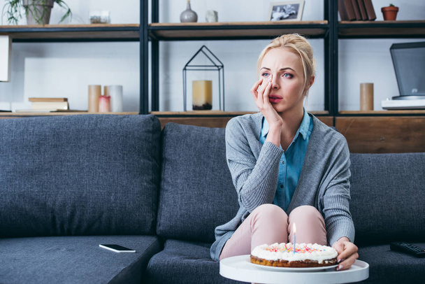 hermosa mujer limpiando lágrimas y llorando mientras celebra cumpleaños en casa solo
 - Foto, Imagen