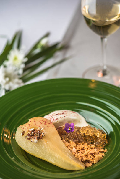 Dessert with pear served on green plate - 写真・画像