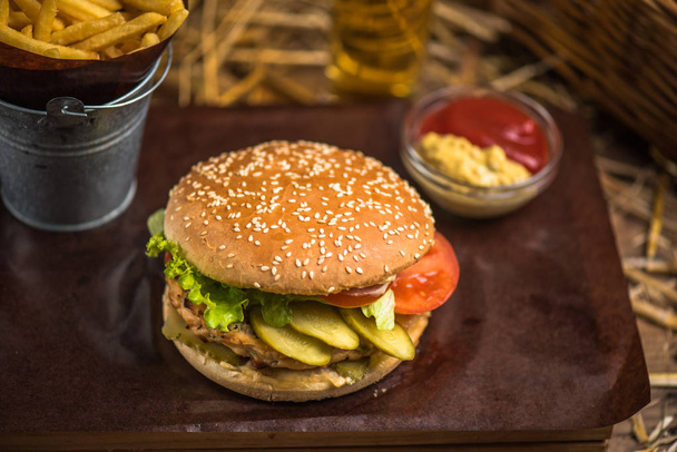 leckere Burger mit Pommes auf Holzbrett - Foto, Bild