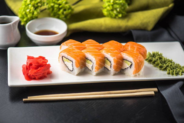 Japanese cuisine - sushi with seafood on a white plate. Roll with fish close-up  - 写真・画像