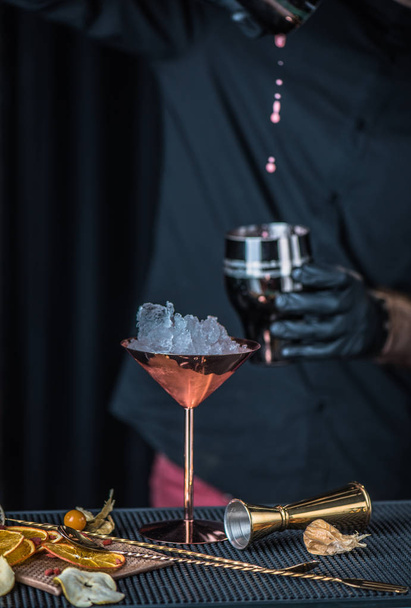 γκρο πλαν του μπάρμαν στο μαύρο προετοιμασία κοκτέιλ στην αντίθεση σε μπαρ - Φωτογραφία, εικόνα