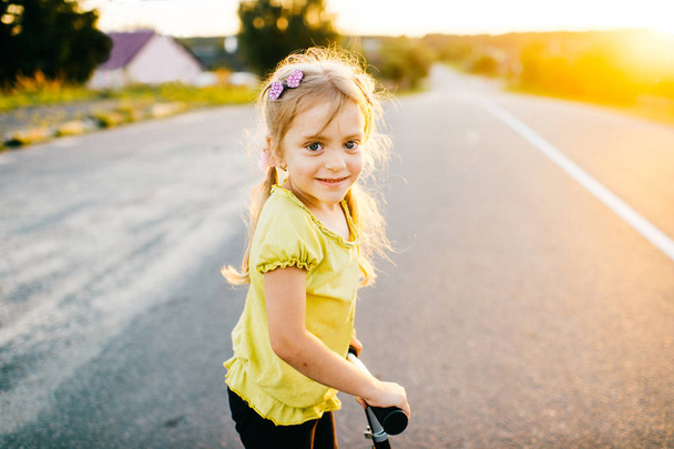 little cute girl riding scooter at countryside - Φωτογραφία, εικόνα